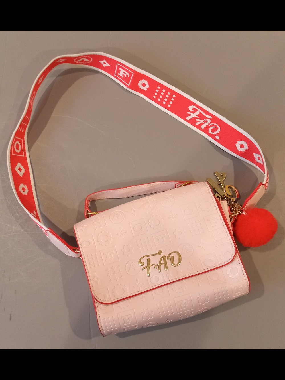 FAO Blush Embossed Crossbody Bag with Red Strap and Pom